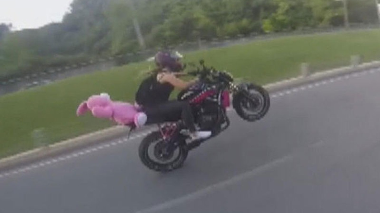 Pembe ayıcıklı motorcu tek teker üstünde gitti