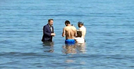 Takım elbise ile denize girip oy istedi