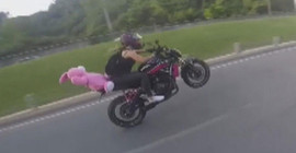 Pembe ayıcıklı motorcu tek teker üstünde gitti