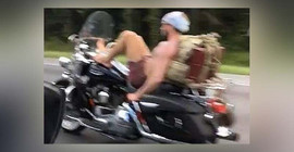 Motosikleti ayağıyla süren adam