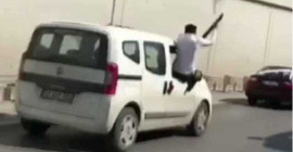 Aracın camından sarkıp havaya ateş etti
