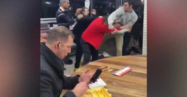 Yanındaki kavgaya aldırış etmeden kebabını yemeye devam etti