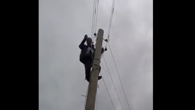 Elektrikleri uzun süredir kesik olan köyün muhtarı durumu protesto için direğe tırmandı
